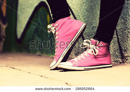 stock-photo-close-up-of-pink-sneakers-worn-by-a-teenager-grunge-graffiti-wall-concepts-of-teen-rebel-186952664